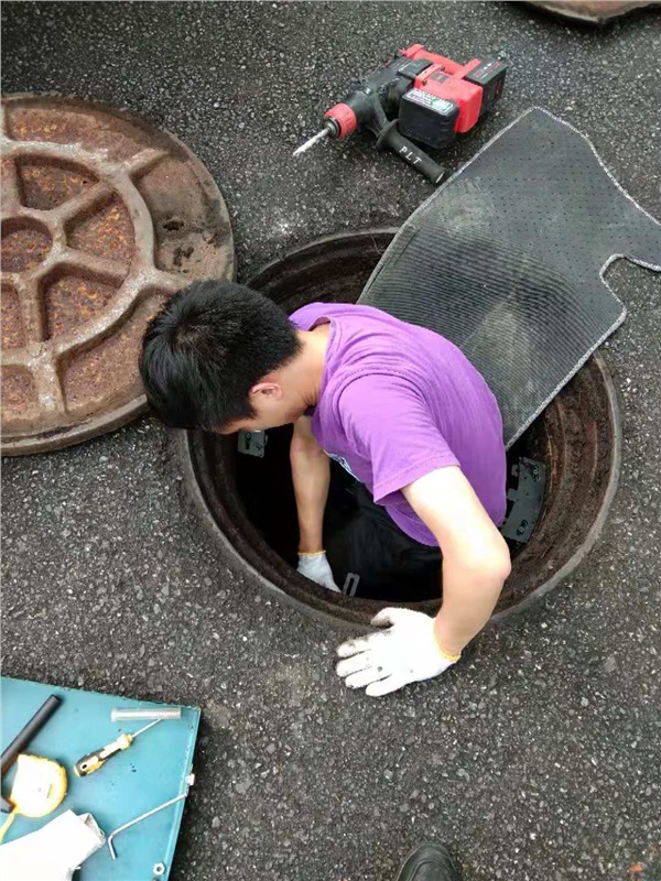 湖南新光工作人员正在安装智能电子锁井盖